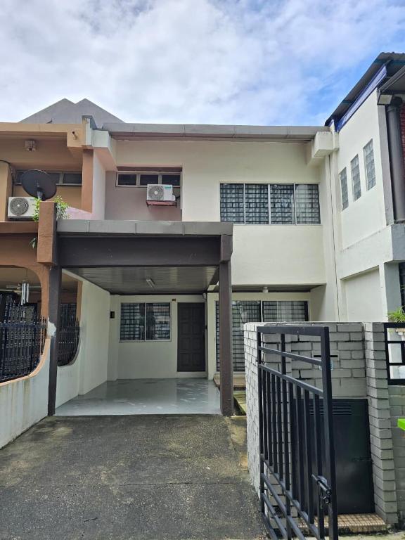 a large white house with a gate in front of it at TWS Homestay in Batu Caves