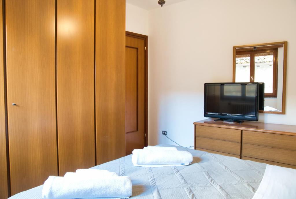 a bedroom with a bed with a television on a dresser at Cuor di Barzio P1 in Barzio