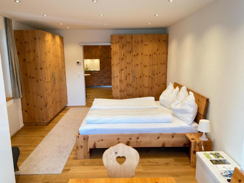 a bedroom with a bed with a wooden wall at Zum Rota Hus in Arosa