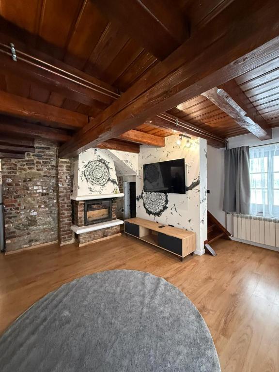 a large living room with a stone wall and a tv at Domek Ostoja Energylandia Zator Graboszyce in Graboszyce