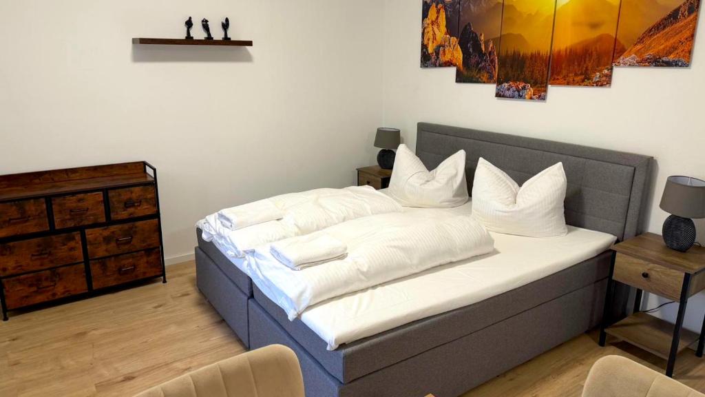 a bedroom with a bed with white sheets and pillows at Bitterfeld Apartment modern & gemütlich in Holzweißig