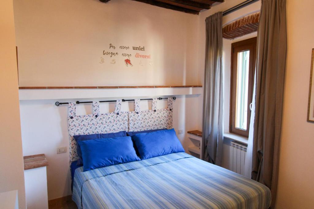 a bedroom with a bed with blue pillows at Casa Carlo in Rio Marina