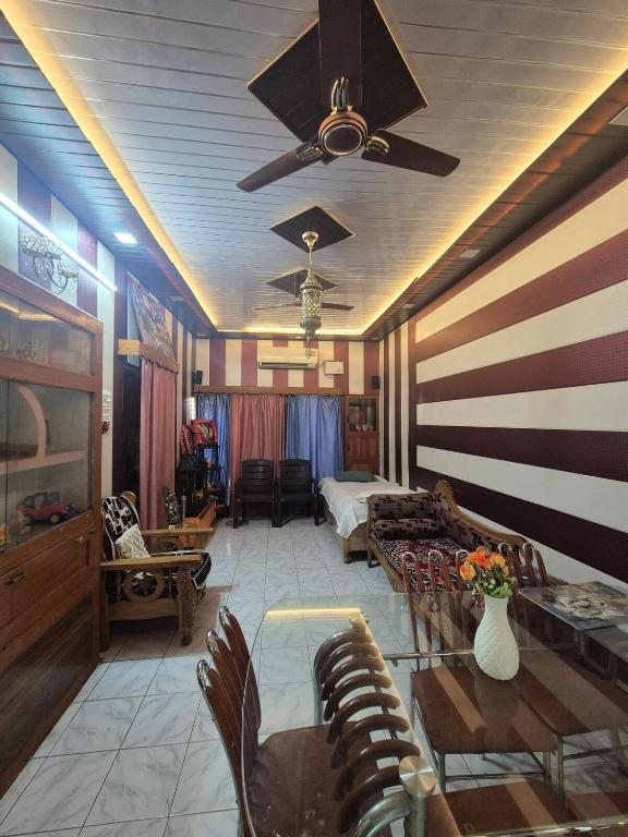 a living room with a couch and a ceiling fan at Triveni Bliss in Prayagraj