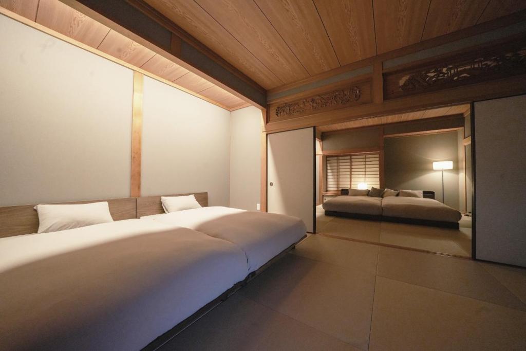 a bedroom with a large bed and a mirror at Hakusyu - Vacation STAY 11460v in Aso
