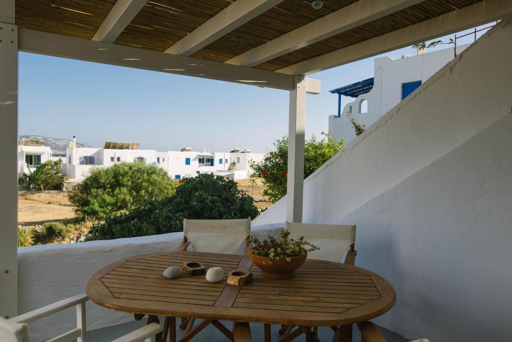 a wooden table on a balcony with a view of a city at Anna's House in Koufonisia