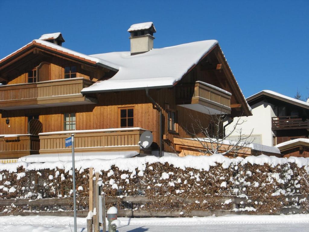 a large wooden house with snow on it at Christina's Bergblick in Oberammergau