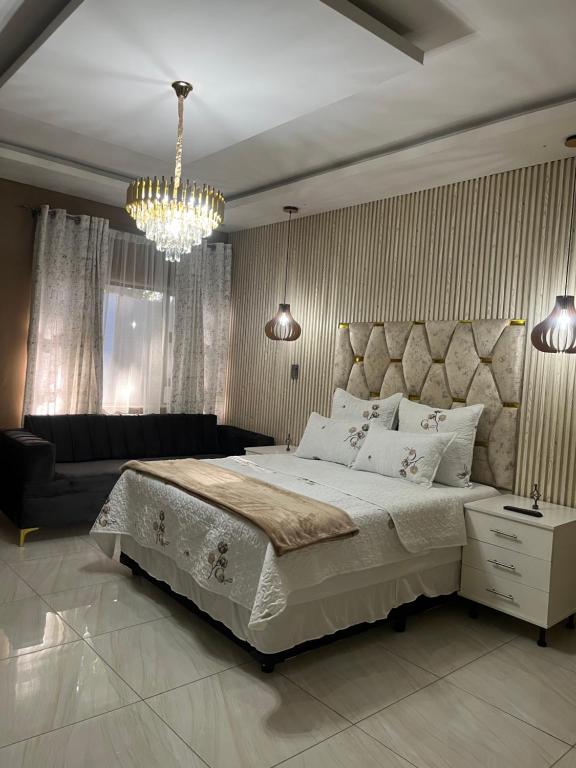 a bedroom with a large bed and a chandelier at M & J Executive Suites in Johannesburg