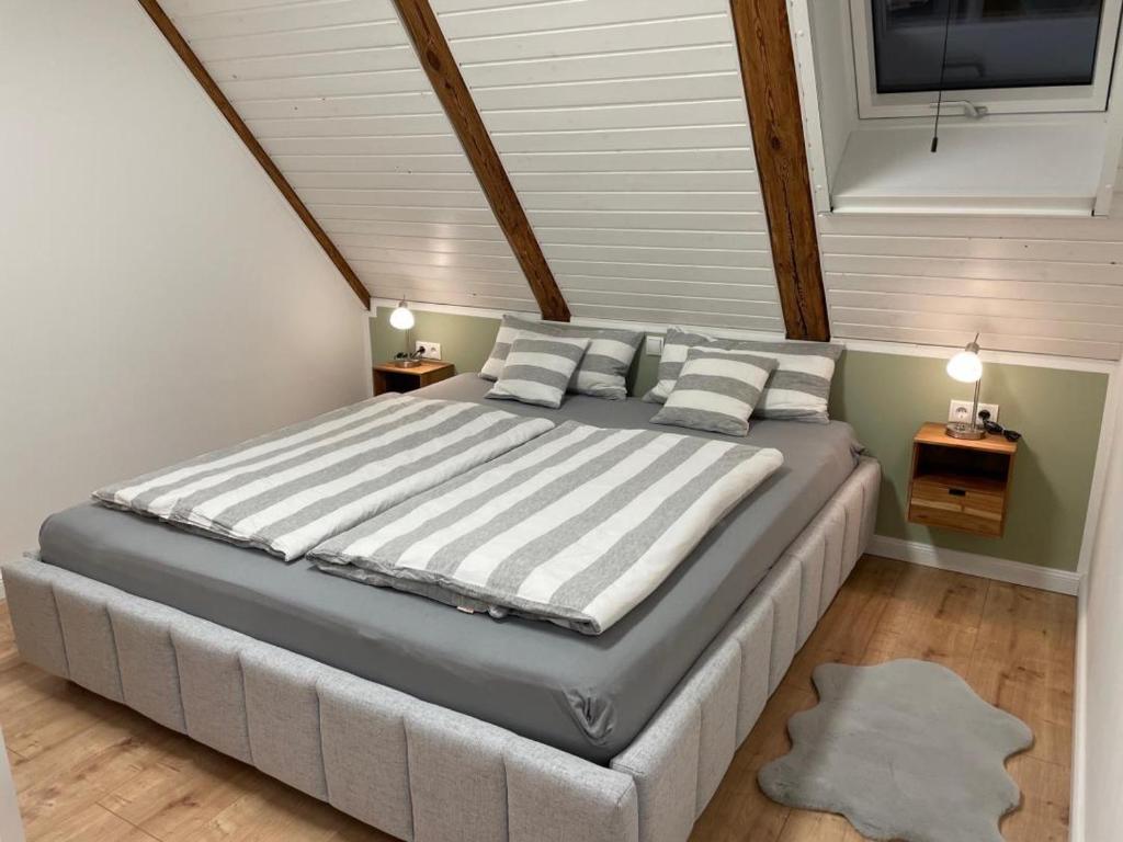 a bedroom with a large bed with striped pillows at Ferienhaus Alex - Wohnung im DG in Malliß