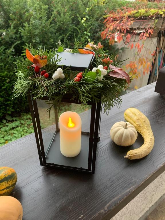 a candle sitting on a table with vegetables and pumpkins at Seelenbaumlerin in Schliersee