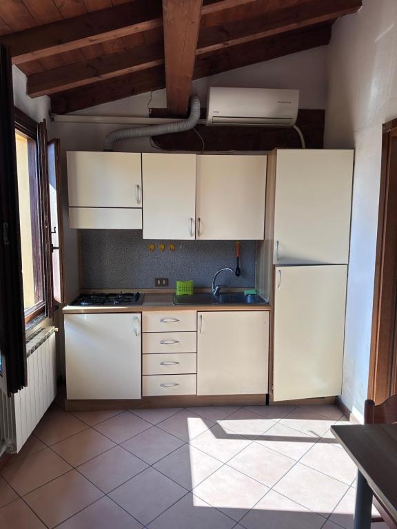 a kitchen with white cabinets and a sink at Dante 12 Flat in Cremona