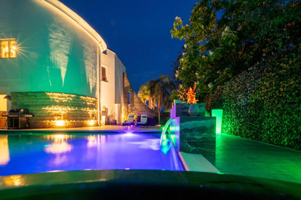 a swimming pool with lights in a building at night at Pink Moon Private Luxury Villa Secluded Garden 5 Bedroom 4 en suite Bathrooms with Private Pool CAT 6 WiFi Close to Beach in Fontane Bianche