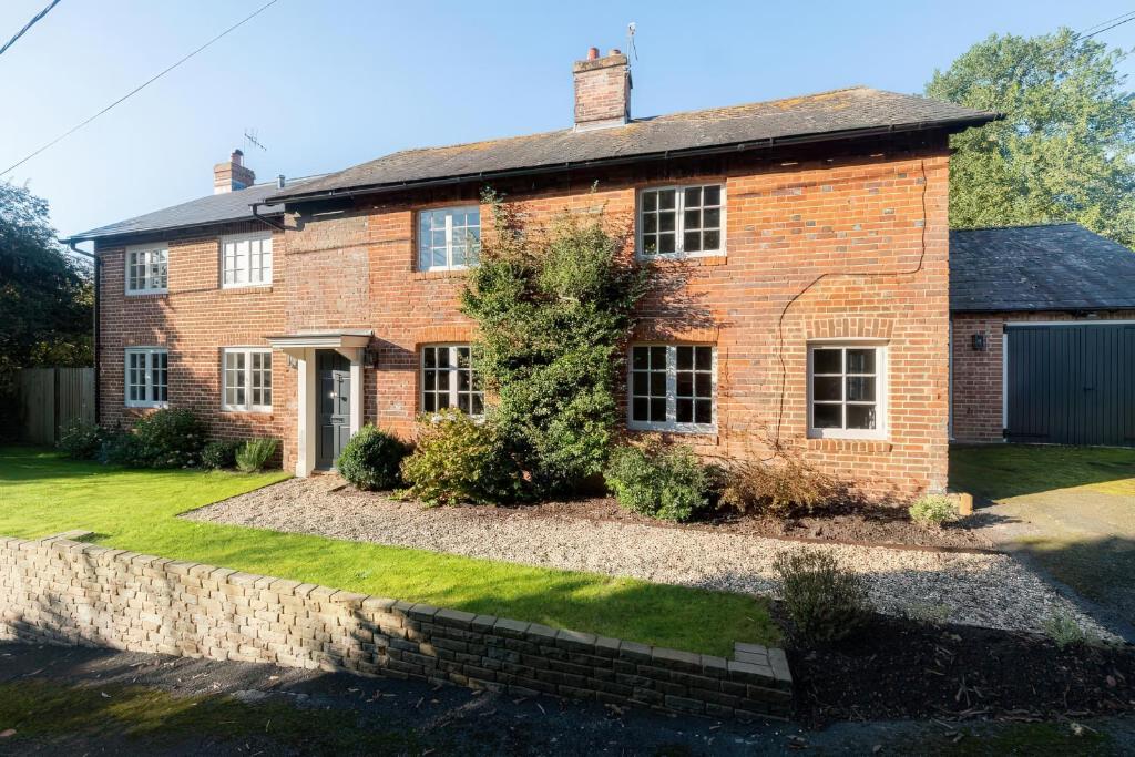 an old brick house with a stone wall at Riverside Cottage in Marlborough
