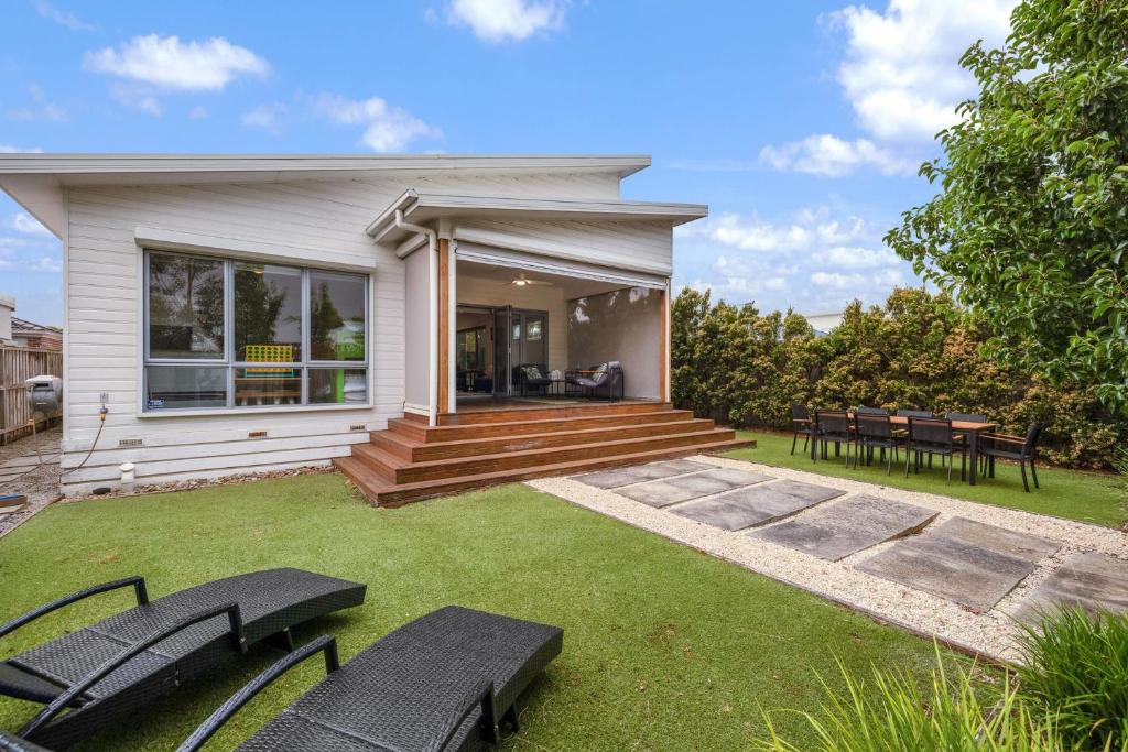 a house with a patio and some chairs on the grass at Guesthouse on Grampian in Cowes