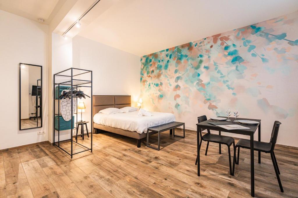 a bedroom with a bed and a table and chairs at suite Tirelire, centre et paisible in Reims