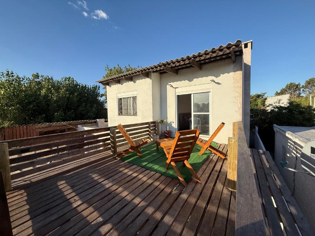 a deck with two chairs and a house at Marvira Barra del Chuy in Xuí