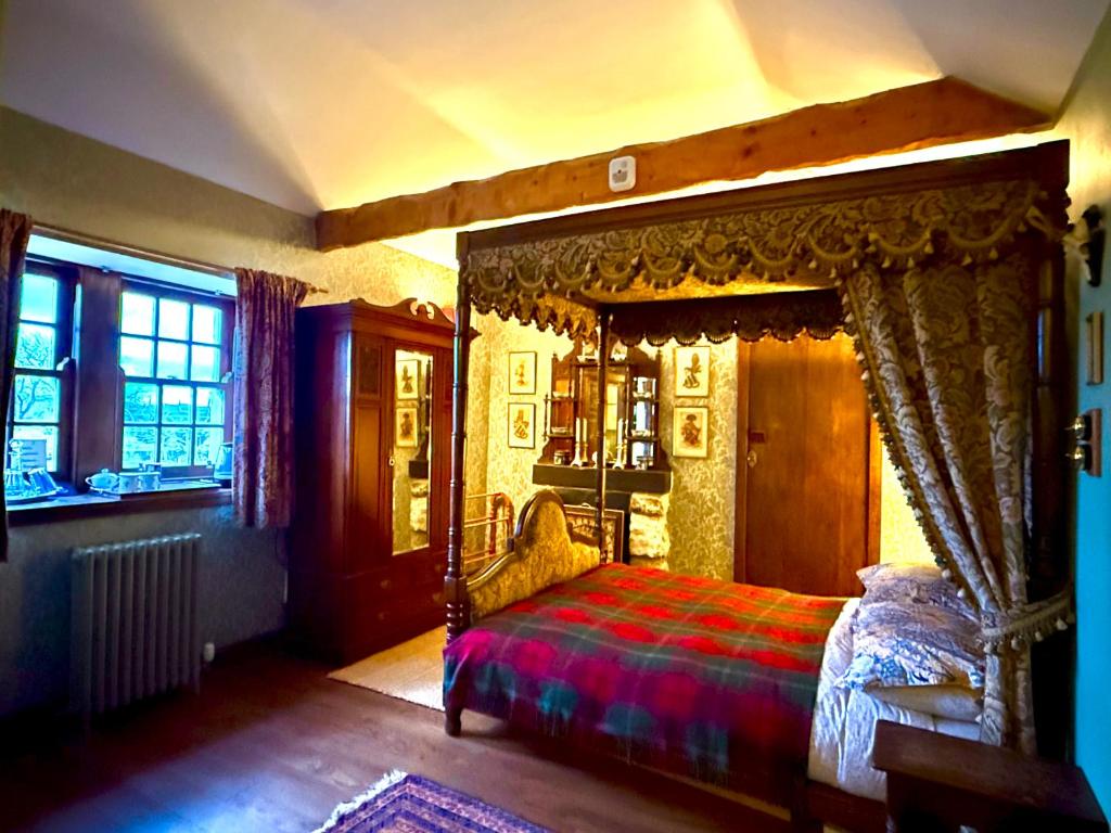 a bedroom with a canopy bed and a window at The Lady Maxwell Room at Buittle Castle in Dalbeattie