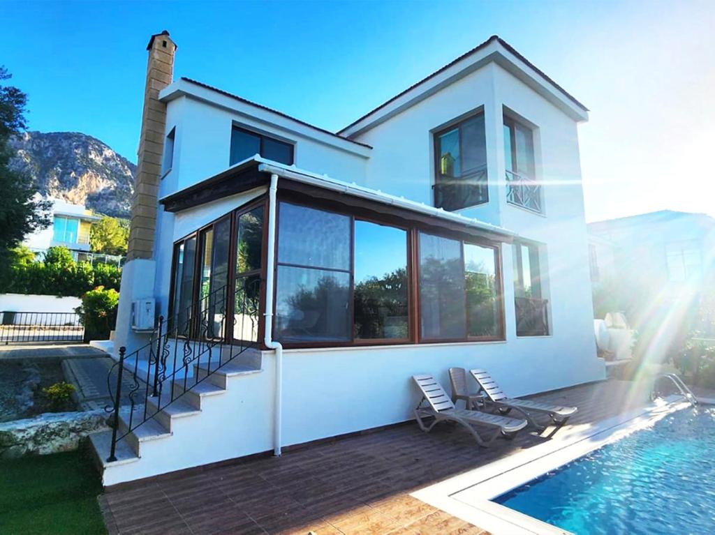a house with a swimming pool next to a house at Villa Amazing by HolidayKeys in Kyrenia