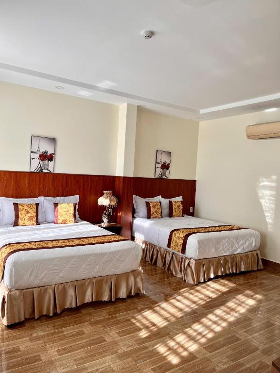 two beds in a hotel room with two beds at HOÀNG ĐẾ motel in Chau Doc