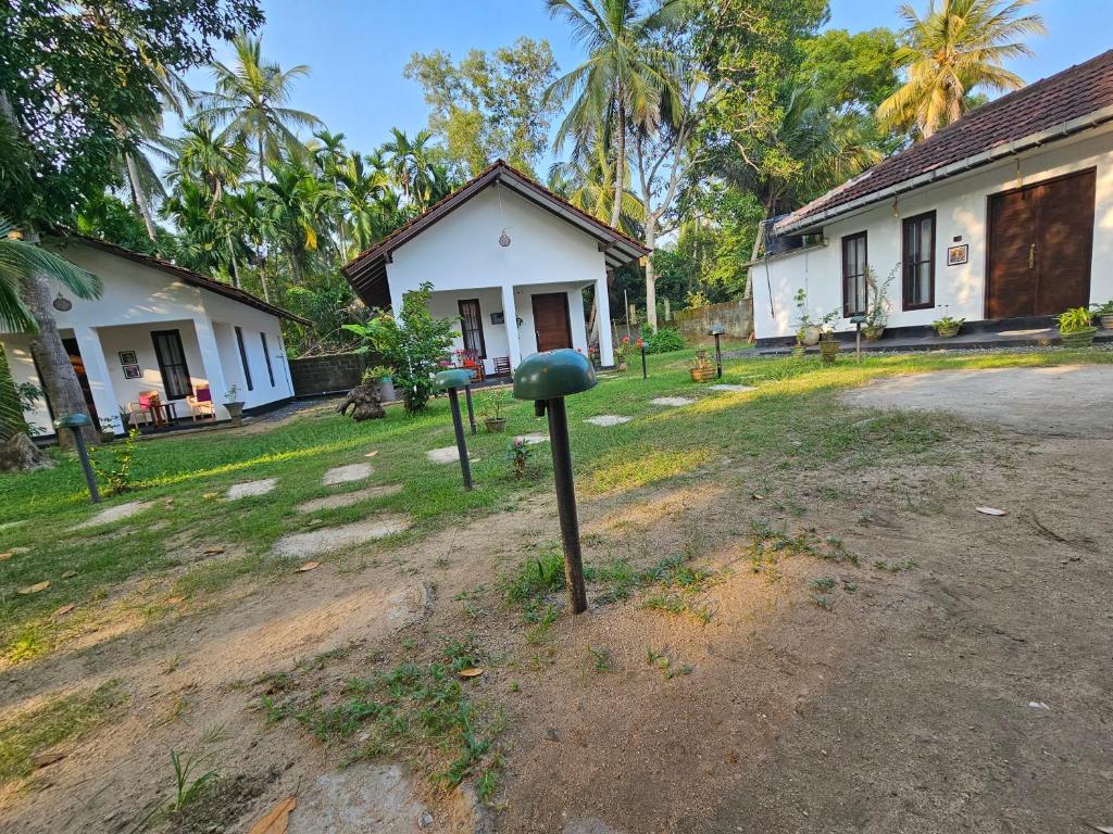 a house with two green spheres in front of it at Charitha Rest in Inginiyagala