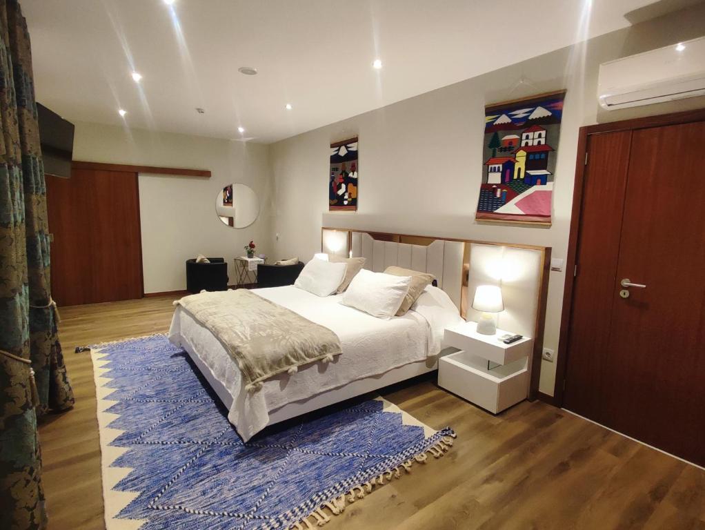 a bedroom with a bed and a blue rug at NetosResidence in Freixo de Baixo