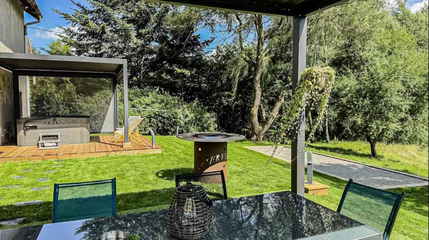 a patio with a table and a grill in a yard at L'échappée aux cerfs SPA in Les Rouges-Eaux