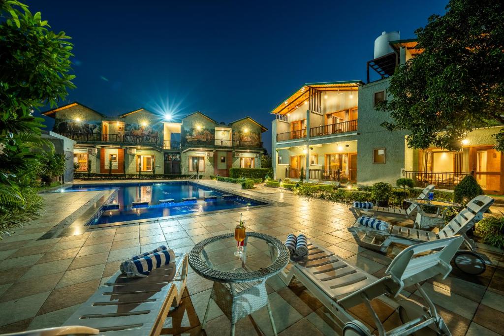 a large house with a swimming pool and a mansion at Corbett Nirvana Resort in Amgarhi