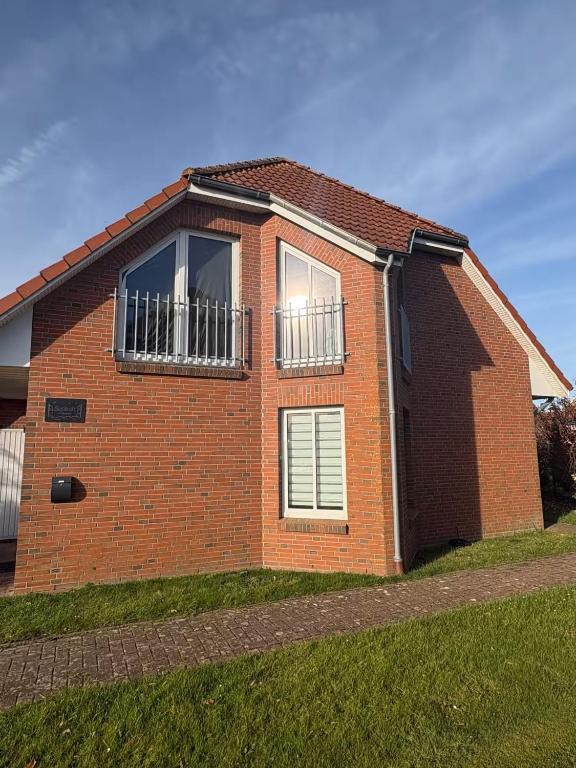 a brick house with two windows on the side of it at Sielkate in Dornum