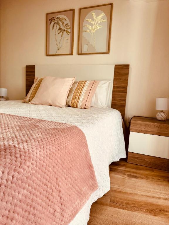 a bedroom with a bed and two pictures on the wall at Casinha da Ti'Augusta in Lamego