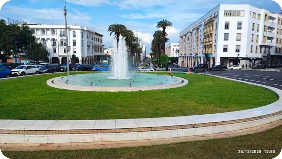 a fountain in the middle of a street with buildings at Centre-ville rabat in Rabat