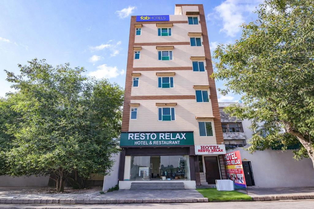 a tall building with a sign in front of it at FabHotel Resto Relax in New Delhi