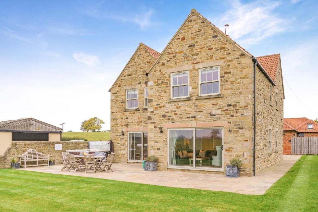 a large stone house with a patio and lawn at 4 Bed in Catterick oc-y33625 in Catterick Bridge