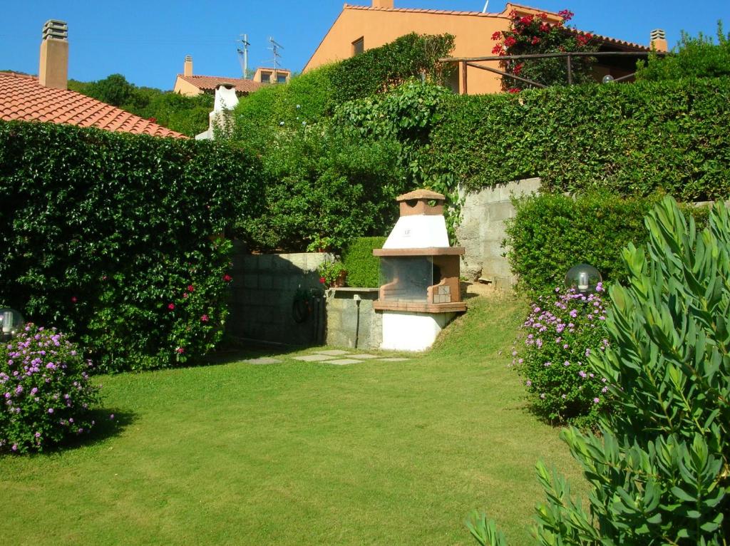 a garden with a small oven in the middle of a yard at Villa Silvia in Costa Rei