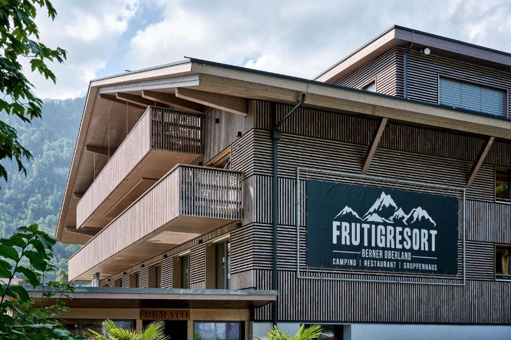 a building with a sign on the side of it at Gruppenhaus Frutigresort in Frutigen