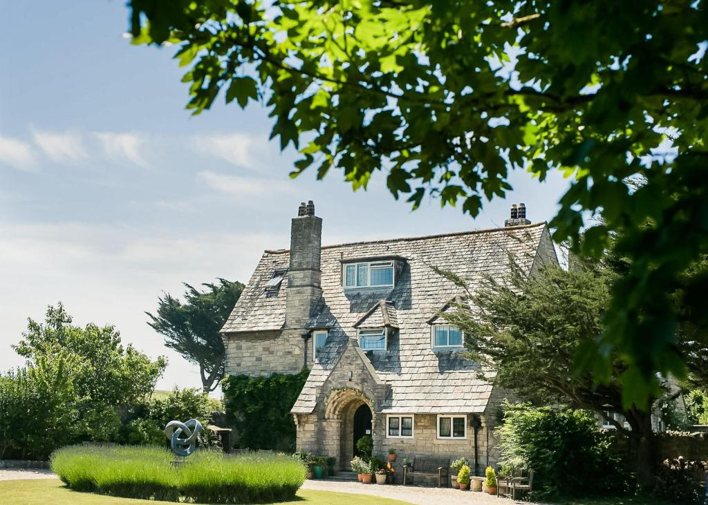 an old stone house with a fountain in front of it at Florence House Bed & Breakfast in Seaford