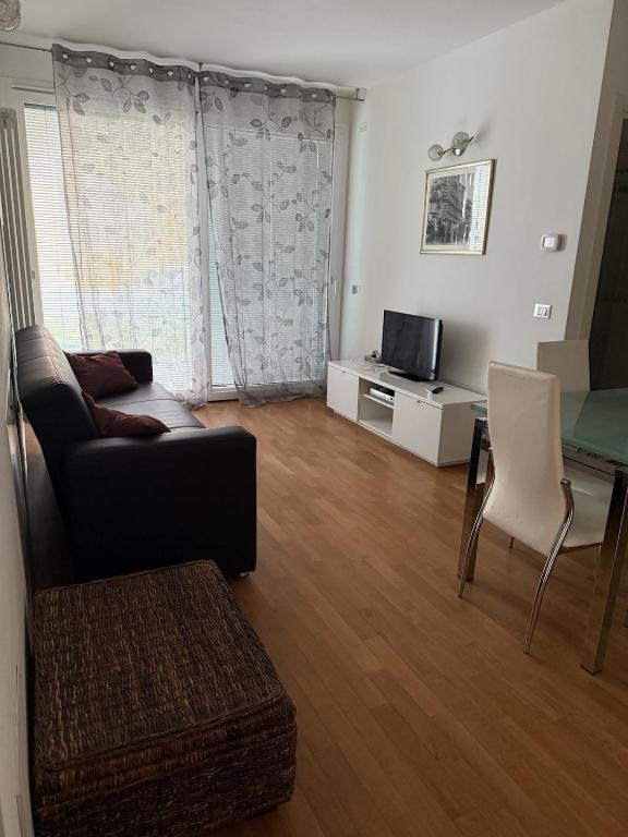 a living room with a couch and a tv at Appartamento Solution Garibaldi in Marina di Ravenna