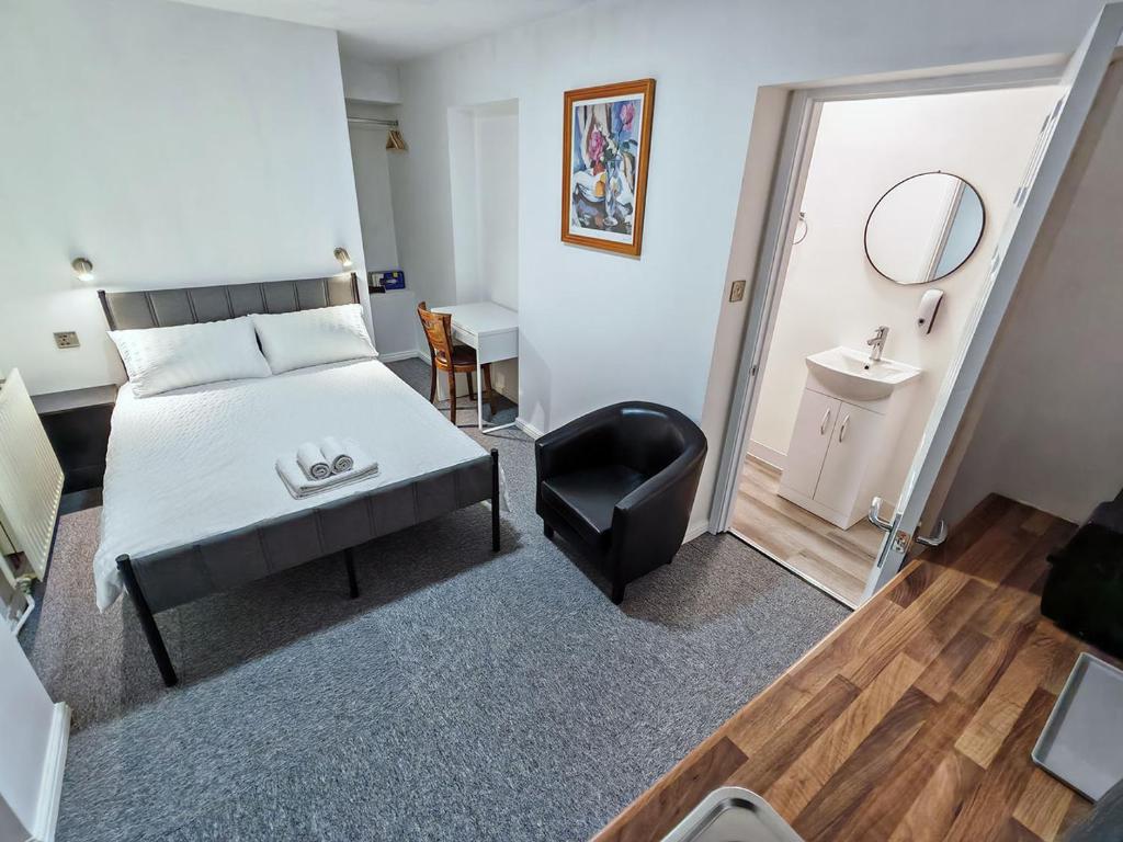 a bedroom with a bed and a chair and a mirror at Rose Studio - Self Contained Studio Flat in Oxford