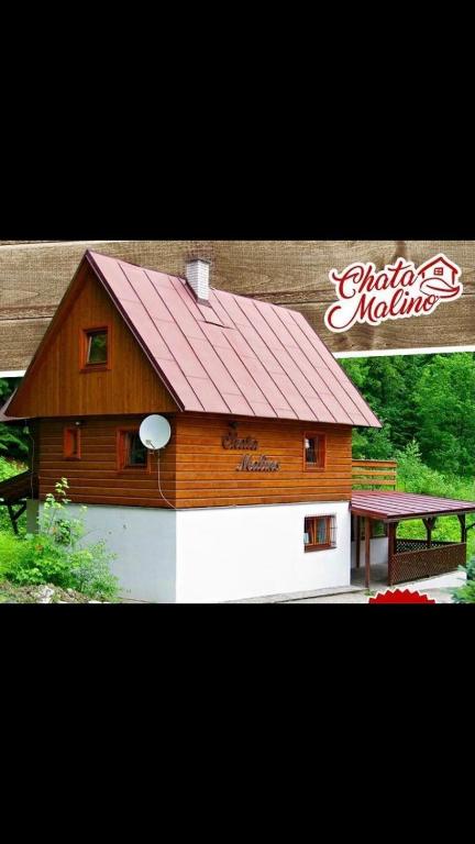 a large wooden barn with a red roof at Chata Malino in Ružomberok