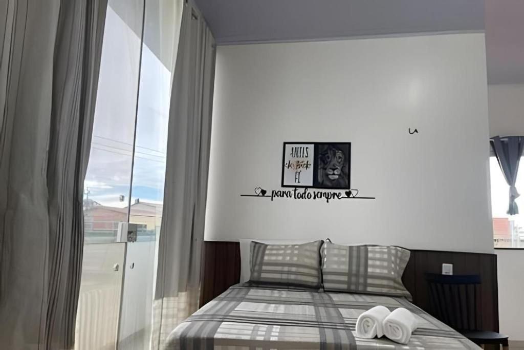 a bedroom with a bed with two towels on it at Apartamentos Vitória – Conforto e Excelente Localização in Barreirinhas