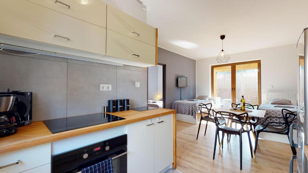 a kitchen and a living room with a dining room at Apartament Fibra Flat White in Rybnik