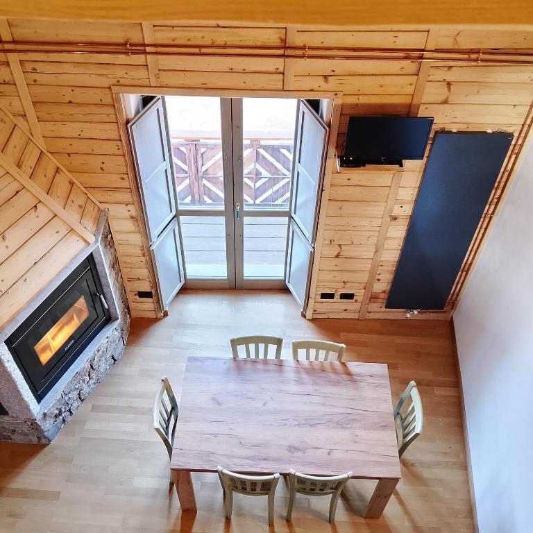 a dining room with a table and a fireplace at Ca Poschiavini - Casa Lares in Casa Piali