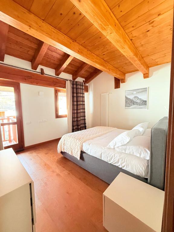 a bedroom with a bed in a room with wooden ceilings at Maison Poluc - Maison Monte Rosa in Champoluc