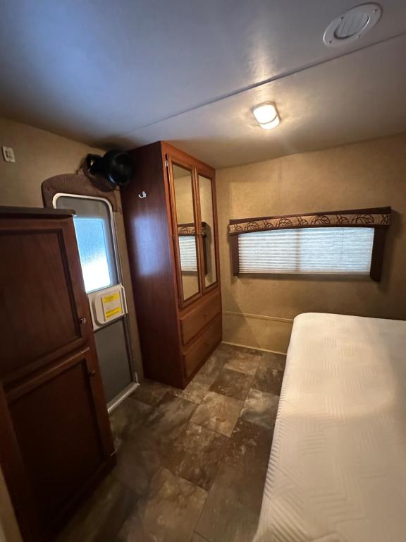 a small room with a bed and a window at Rustic cozy couples summer stay in Little Current