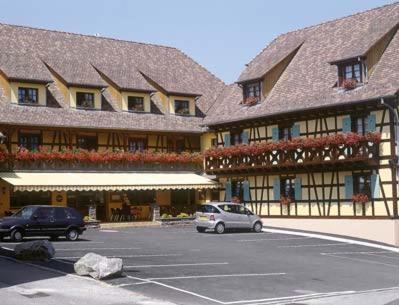 a car parked in a parking lot in front of a building at Hôtel Restaurant AU SOLEIL in Wahlbach