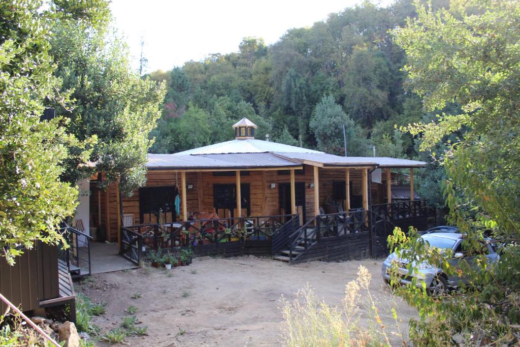 a wooden cabin with a car parked in front of it at Casa Hostal Familiar Espacio SaTaNaMa in El Torreón
