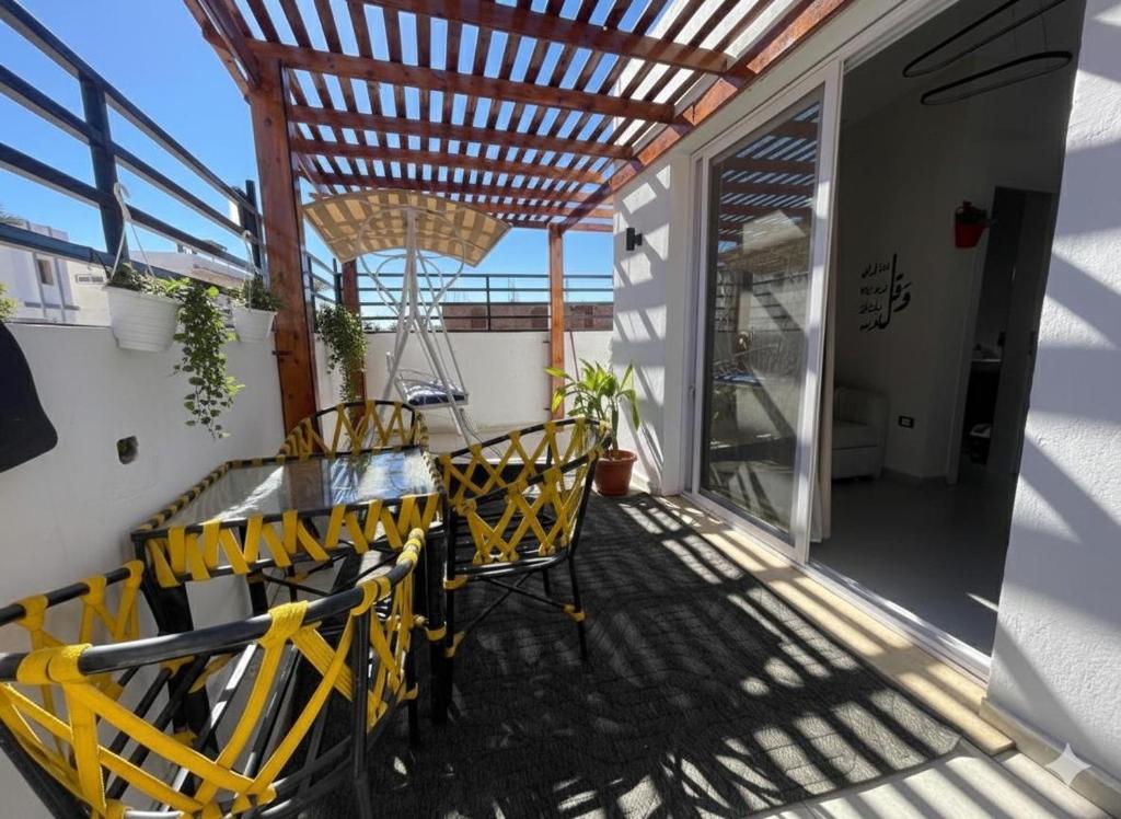 a balcony with a table and chairs and a wooden ceiling at Younis chalet in Dahab