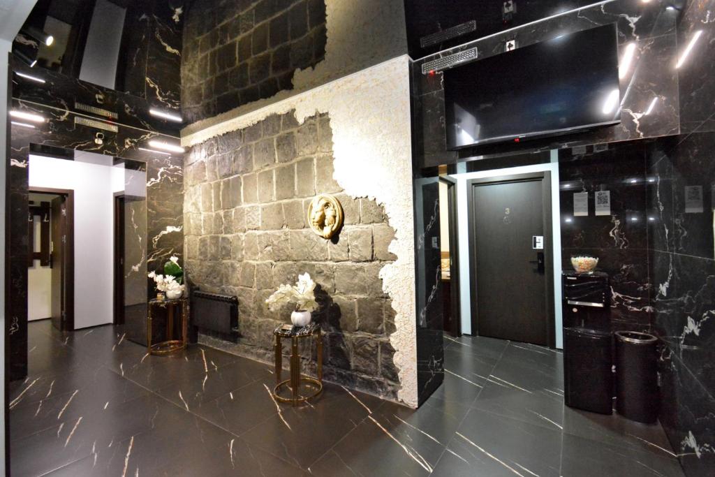 a lobby with a stone wall with a lion head on it at Апарт-отель ЛЕВЕЛ Ереван, Ханджян 47 in Yerevan