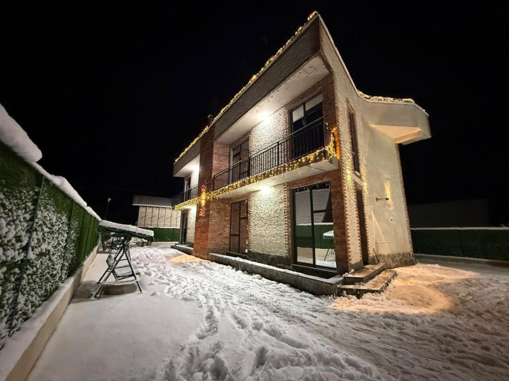 a house in the snow at night at Marhaba Villa in Borjomi