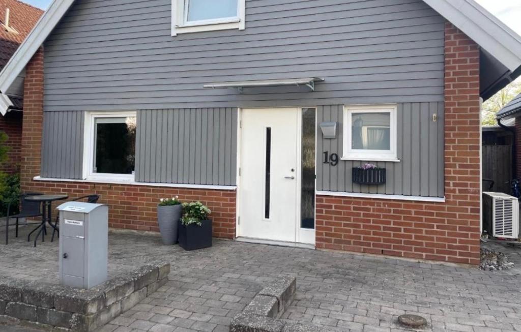 a house with a white door and a patio at Hus, barnvänligt, nära strand in Halmstad