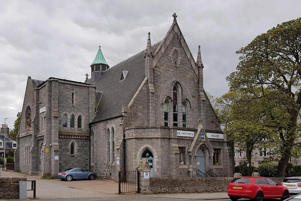 an old church with cars parked in front of it at Sanctuary Hotel - En Suite Rooms in Aberdeen