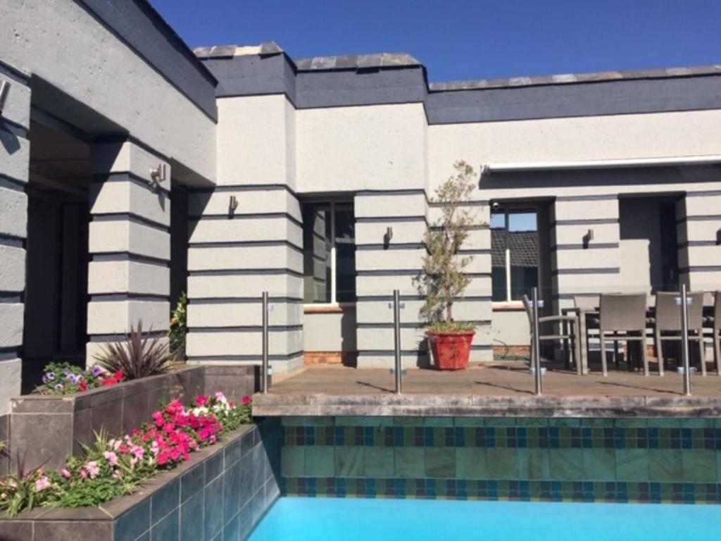 a house with a swimming pool in front of it at Orchids Lodge in Fourways